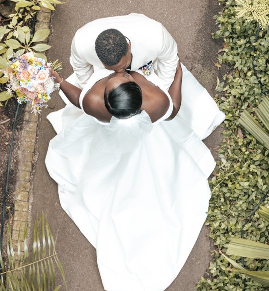 Bruidspaar tijdens de fotoshoot vanaf boven gefotografeerd met trouwboeket